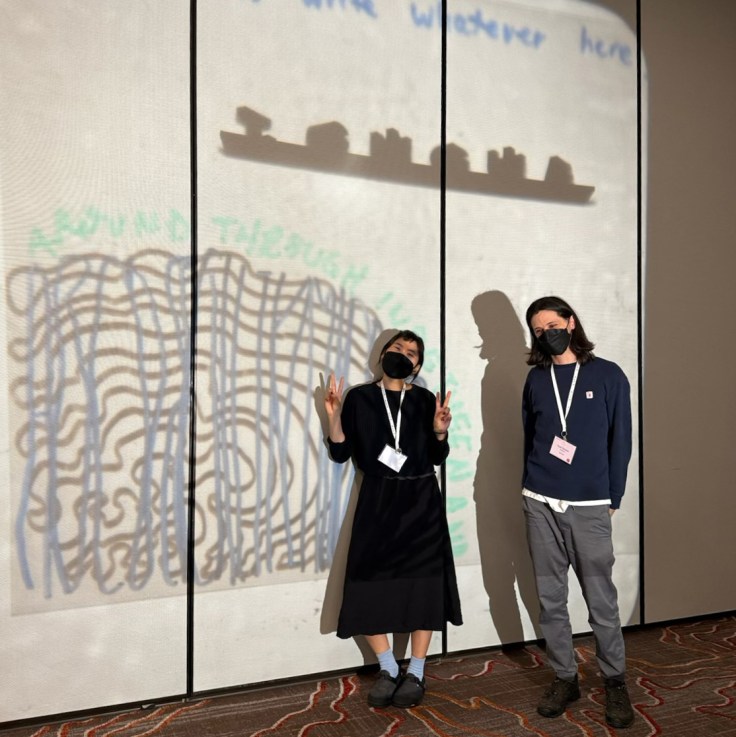 cute pic of us at our โTONGUE-TWISTโ workshop for ALTA48 in Tucson smiling behind masks, with wormy carpet and wormy drawings